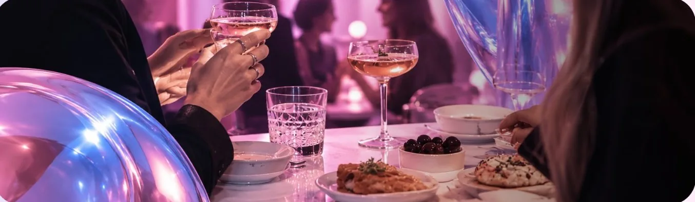 Friends toasting over shared plates at a dinner table