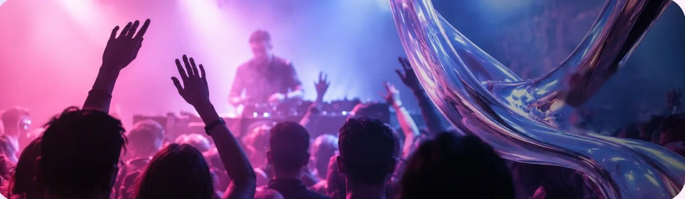 Crowd with raised hands at a DJ set under pink light